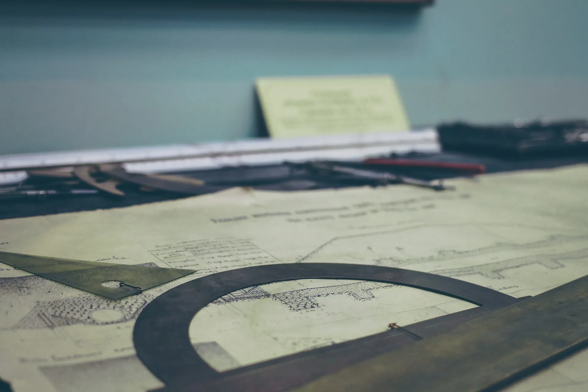 Printed structural drawings and a protractor on a desk